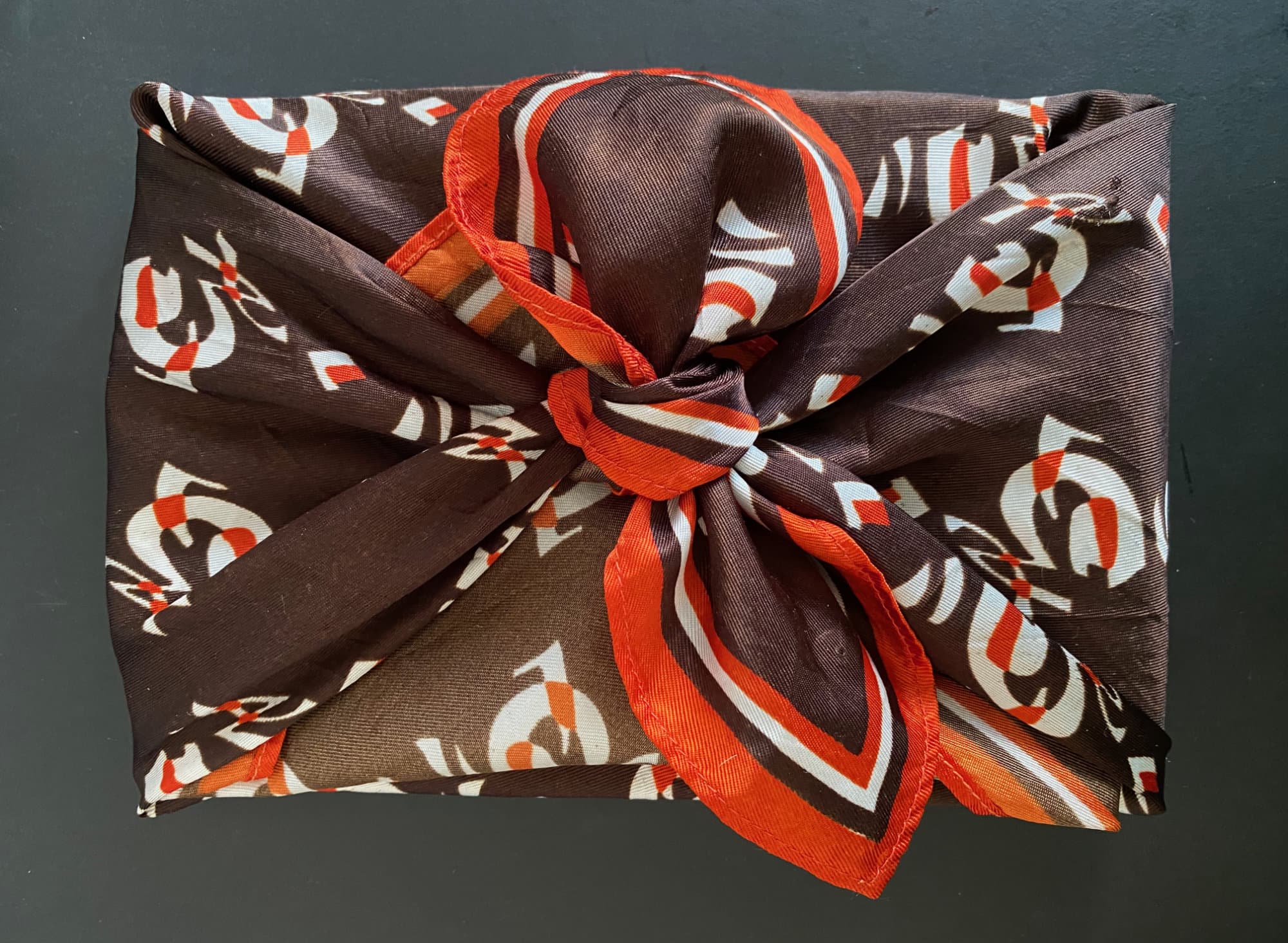 A fondfolio shown wrapped furoshiki-style in a unique vintage scarf.
