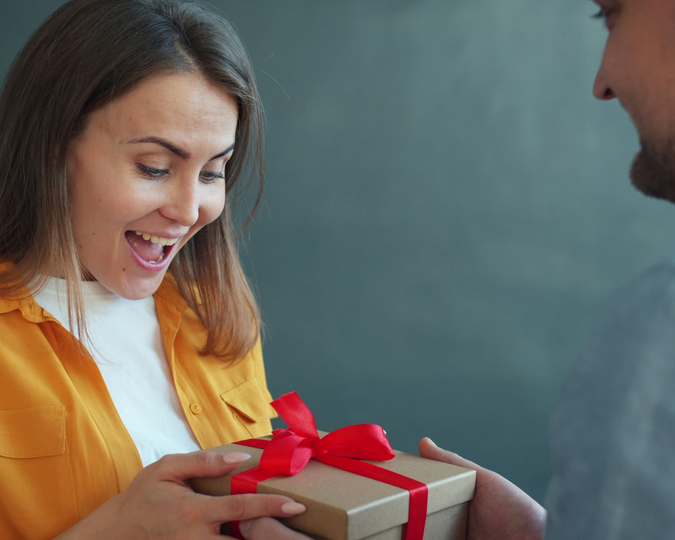 A woman receives a gift and appears to be excited about it.